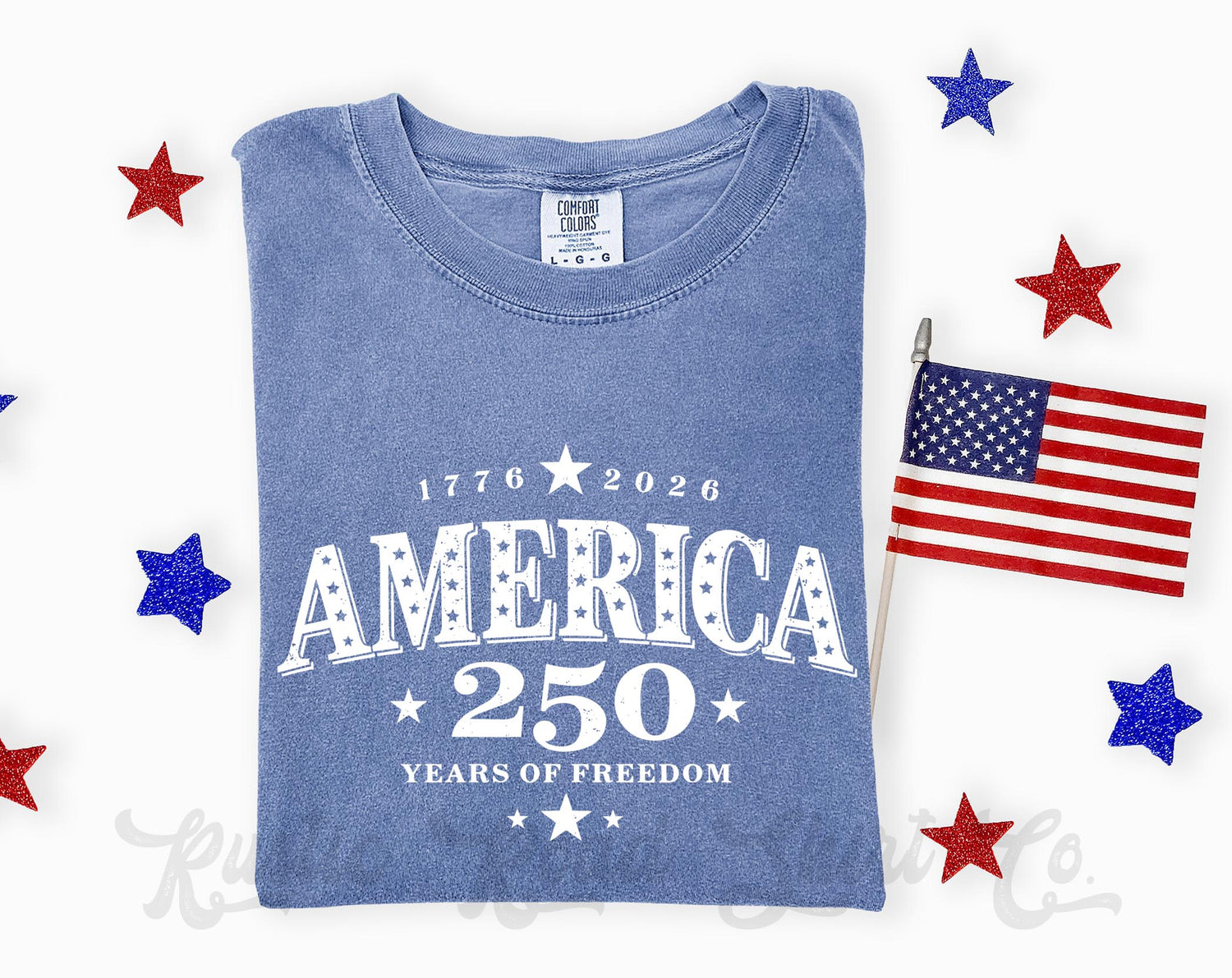 Blue t-shirt with 'America 250 Years of Freedom' text, American flag, and stars on a white background