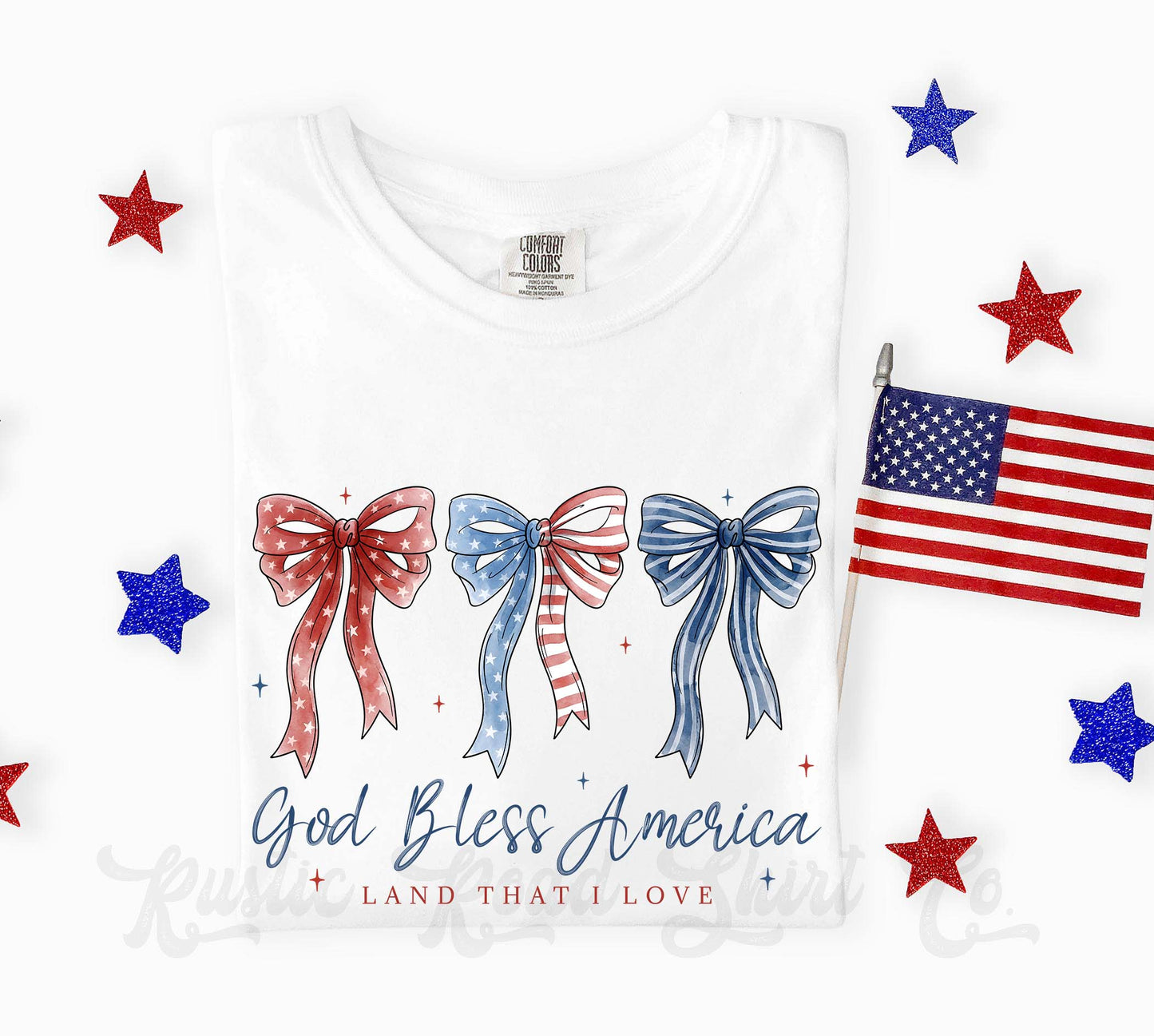 White t-shirt with red, blue, and white bows and an American flag, featuring 'God Bless America' text.