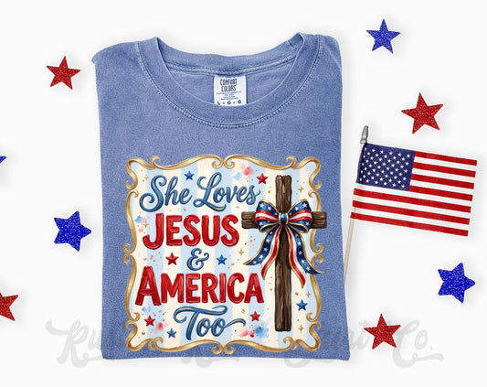 Blue t-shirt with 'She Loves Jesus & America Too' design, surrounded by American flags and stars on a white background.