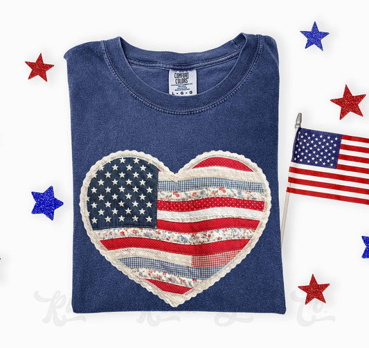 Blue t-shirt with a heart-shaped American flag design on a white background with stars and an American flag.